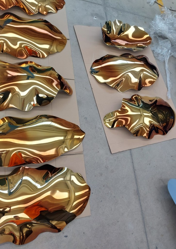 Gold sculptural window components prepared for inspection before packing for the Louis Vuitton Blooming Flowers campaign