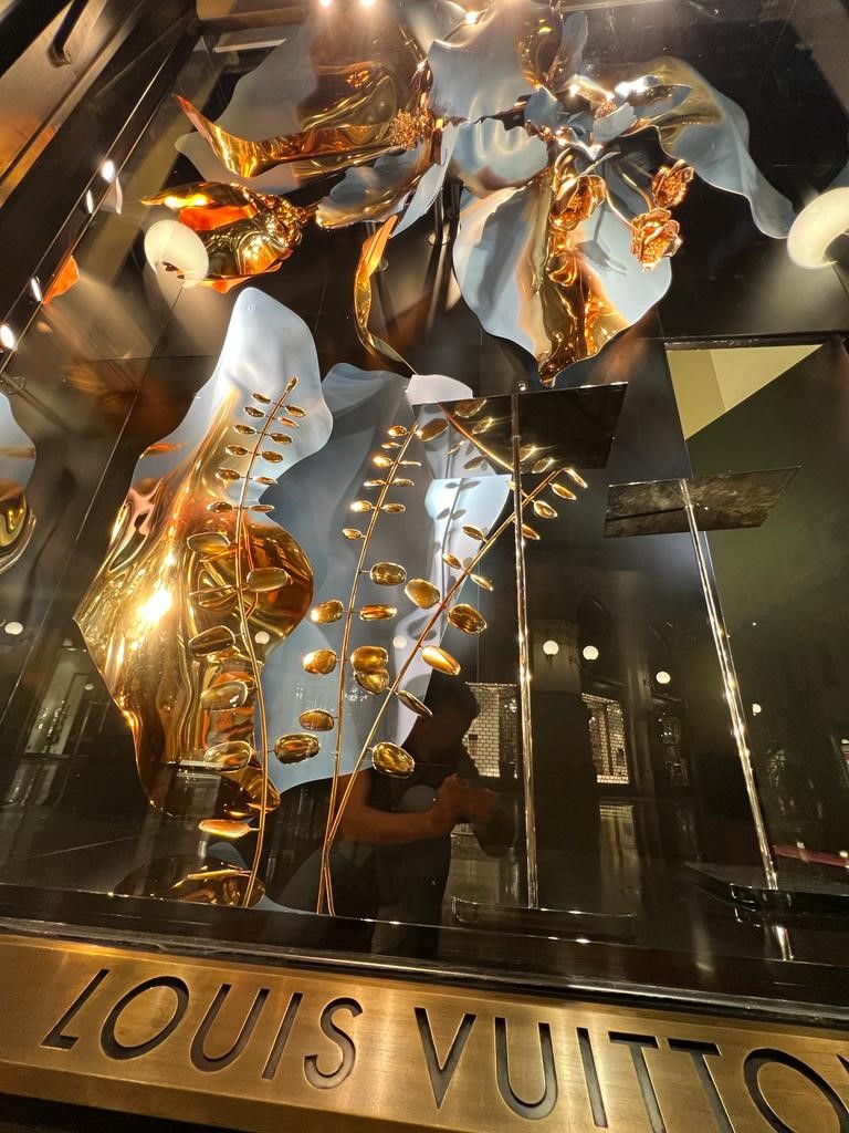 Installed Louis Vuitton Blooming Flowers window display with blue and gold sculptural floral elements