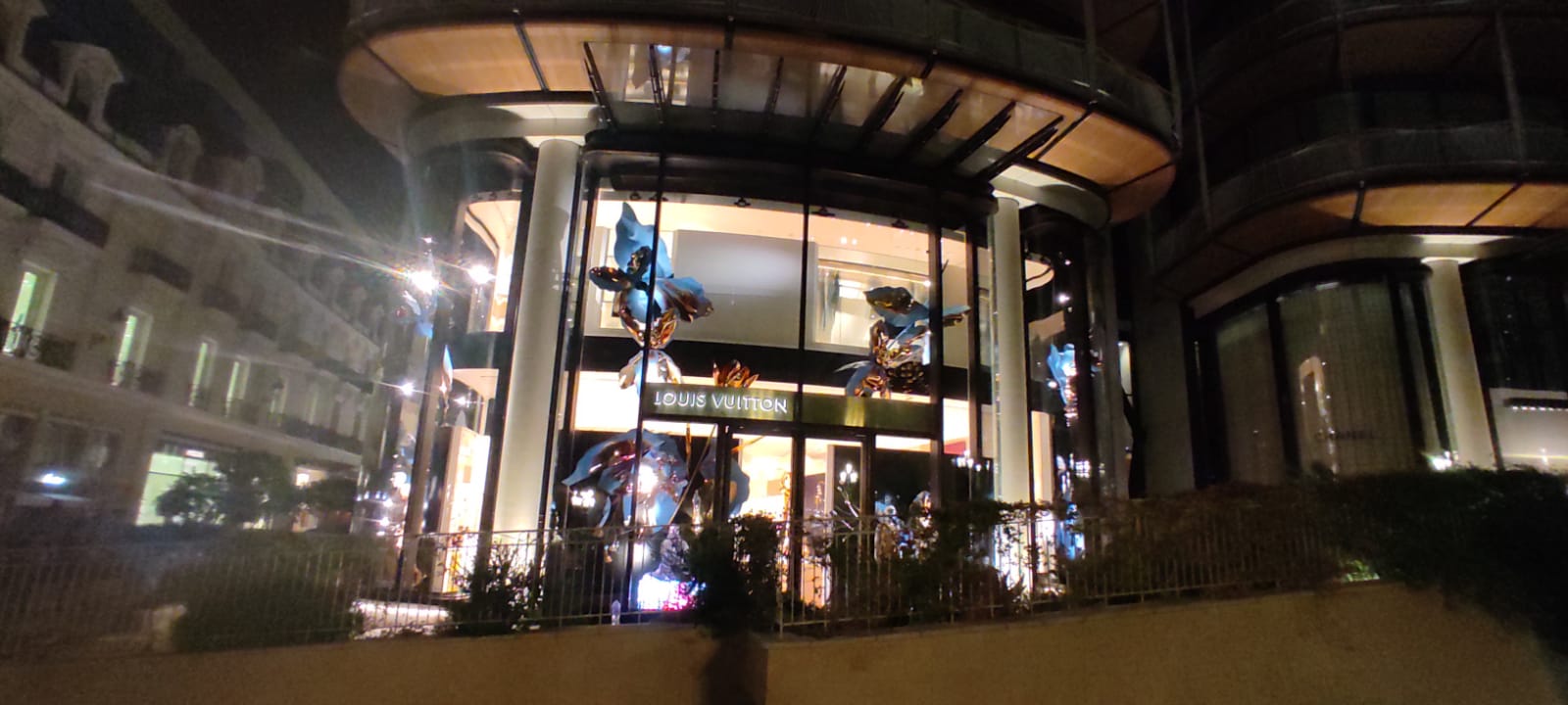 Louis Vuitton storefront at night with the Blooming Flowers window campaign fully installed