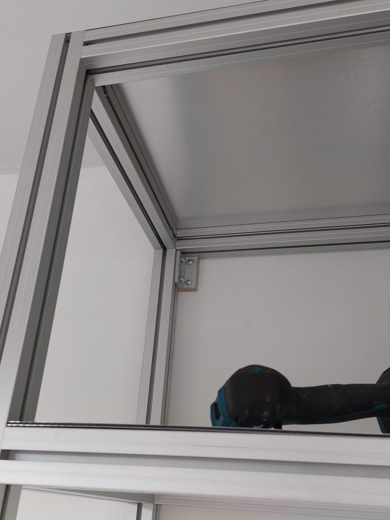 Technical detail of the aluminium profile shelving system during installation for the Oltrefrontiera Material Library